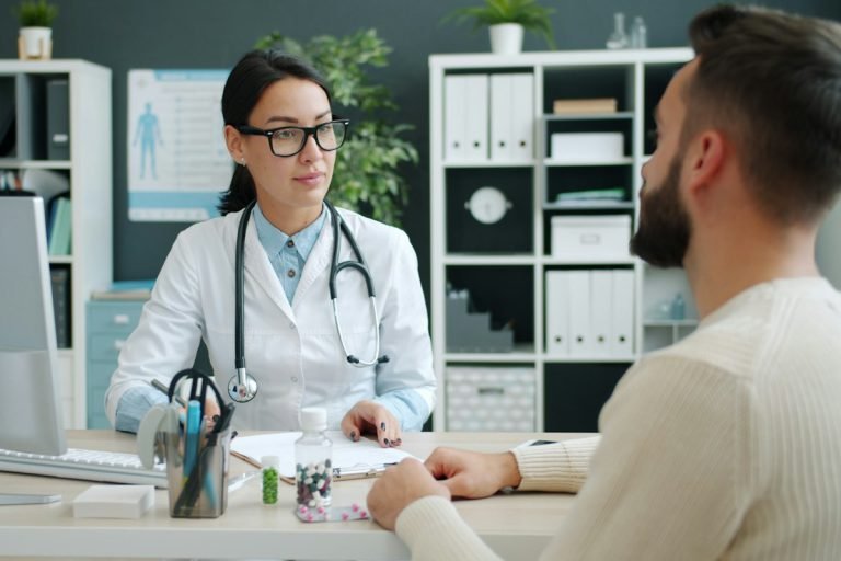 Doctor talking with a patient at a clinic desk